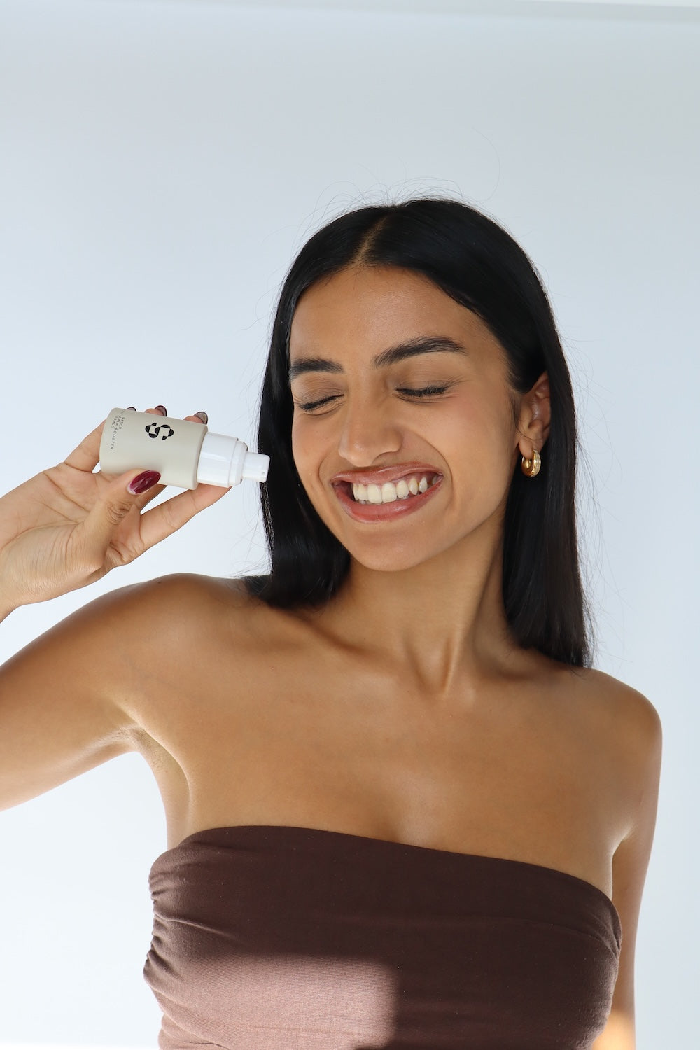 Women with Clear, Glowing skin holding the Satori Skin Booster Serum - Mandelic Acid, Lactobionic Acid and Amla - boost radiance, fade pigmentation, and strengthen skin’s resilience. Gentle yet effective, it’s ideal even for sensitive skin. Indian Heritage Routine and Rituals